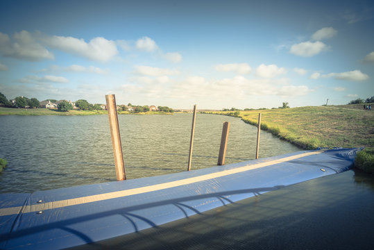 Inflatable dam near a lakeside residential neighborhood and a levee in Irving, Texas, USA. Water filled cylindrical tubes act as rubber temporary, industrial grade geo-textile material barrier