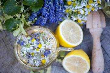 Cup of herbal tea with wild flowers and various herbs 