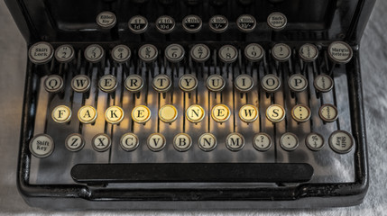 Ancient vintage portable typewriter spelling fake news