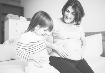 Pregnant mom spending time together with her daughter