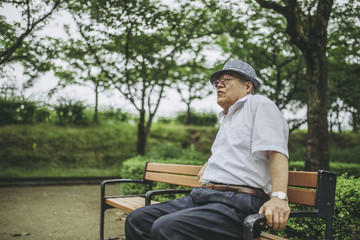 Fototapeta premium ベンチに座る高齢男性