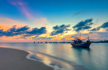 Sunset and boat on the sea as the sun slowly down the horizon circle creates a beautiful golden light on the bay. It's great to idyllic scenery here.