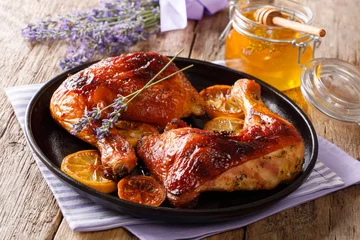 Fotobehang French food: fried quarters chicken legs with lavender honey, spices and lemon close-up. horizontal © FomaA