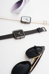 close up of wristwatches with sunglasses for background