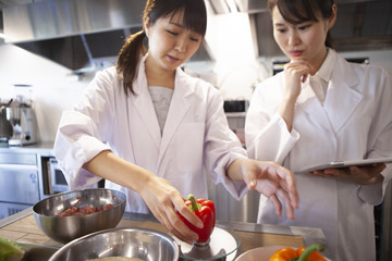 栄養士たちパプリカの重さを計測している