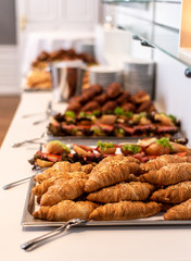 many delicious croissant bread stacked on a buffet line
