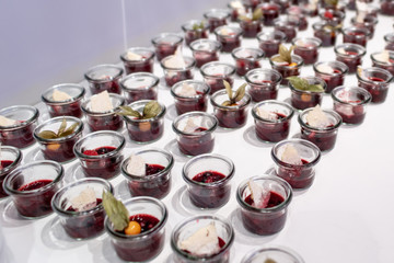 Closeup many dessert jar rowed up on buffet table with fresh fruits jelly and cream