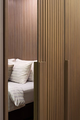 Pattern of brown wooden closet in bedroom with white pillows