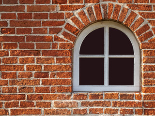 Obraz premium old arch window in bricks wall horizontal
