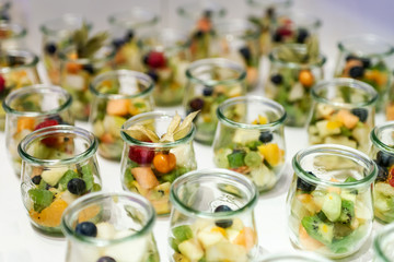 Closeup many dessert jar rowed up on buffet table with fresh fruits jelly and cream