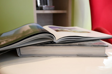 Open book with photo on white table.