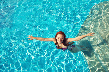 woman relaxing by swimming pool