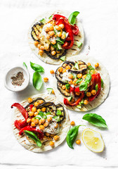 Grilled vegetables and spicy chickpeas vegetarian tortillas on a light background, top view. Healthy food picnic vegetarian concept. Flat lay