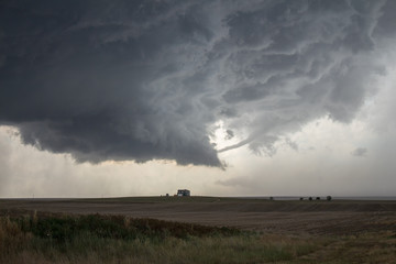 Fototapeta na wymiar A rope tornado funnel dissipates underneath the updraft of a supercell thunderstorm.