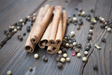 Pepper and cinnamon sticks on wooden table