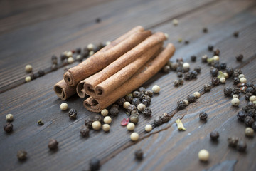 Pepper and cinnamon sticks on wooden table