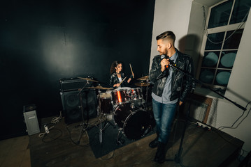 Wedding in the style of rock. Guys with stylish leather jackets. It's a rock'n'roll baby Sweet couple in a music studio. The bride plays the drums, and the groom sings.