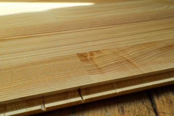 An image of an old wooden floor and a new parquet board.