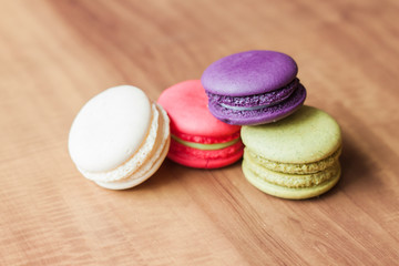 Colorful French Macarons on wooden background.