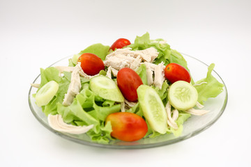Salad with chicken and fresh vegetables isolated on white background.