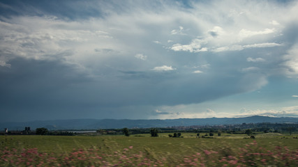 Cloudscape on a green plain field landscape