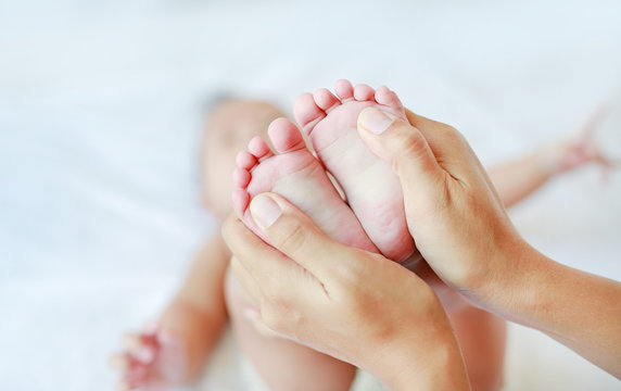 Foot massage for infant baby. Close up.