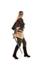 full length portrait of girl wearing medieval costume with sword. standing pose with back to the camera, isolated on white studio background.