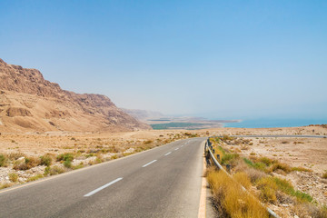 Steep turn of descend highway in Judean desert with Dead Sea in background. Metzoke Dragot, Israel.