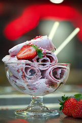 Roll ice cream is made by hand on the freezer. Sweet dessert made from natural strawberries and ingredients.