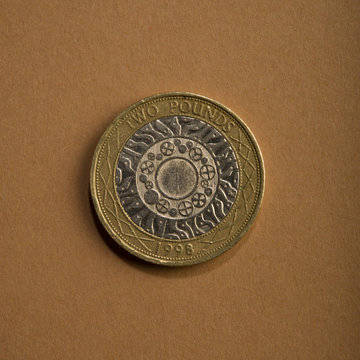 coin of two pounds on a brown background.
