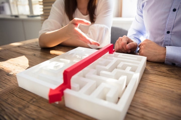 Two Businesspeople Discussing About Solving Maze