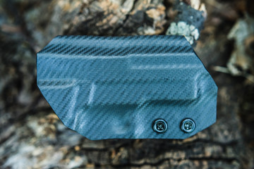 Objective shooting holster on the bark of a tree in the forest