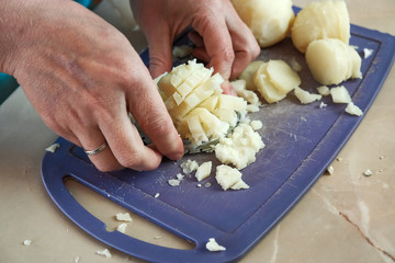 the woman cut boiled potato for salad