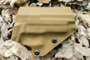 objective holster shooting on dry leaves in the forest