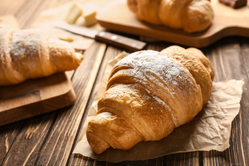 Tasty croissant on wooden background