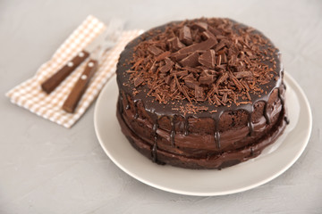 Plate with delicious chocolate cake on light table