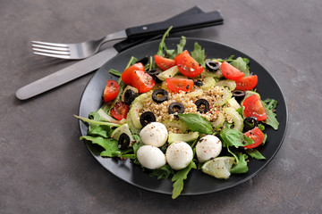 Plate with quinoa salad on grey background