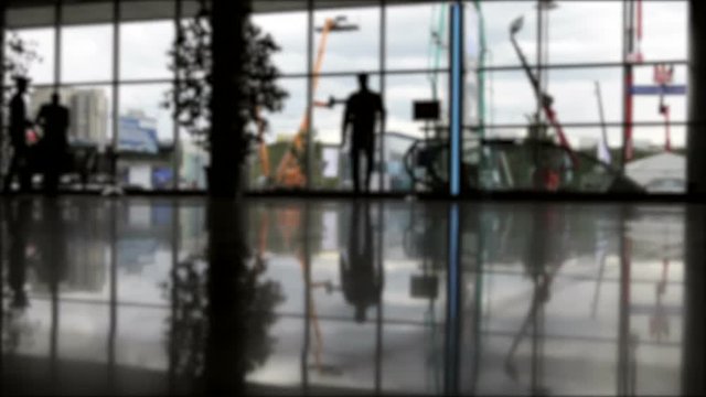 silhouettes of walking people on the background of glass Windows or halls. time lapse video