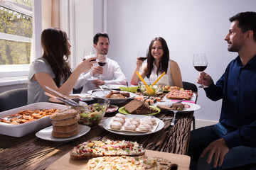 Friends Enjoying Food With Glass Of Wine