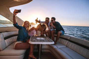Group of people taking selfie at boat party - Powered by Adobe