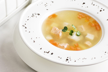 Fish soup with salmon and vegetables in a white plate