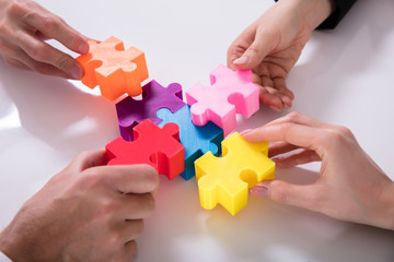 Group Of Businesspeople Solving Jigsaw Puzzle