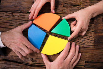 Businesspeople Connecting Pieces Of Pie Chart