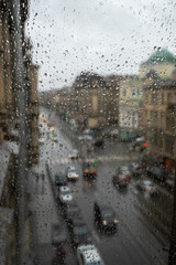 Defocussed traffic viewed through a car windscreen covered in rain