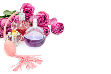 Perfume bottles with flowers on white background. Perfumery, cosmetics, fragrance collection. Copyspace for text.
