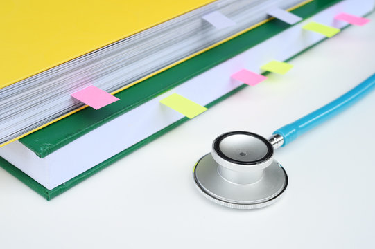 close up of stethoscope with notebook for background