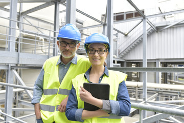 Portrait of smiling industrial engineers standing in recycling plant