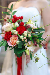 Wedding bouquet of flowers including Red hypericum, Roses, Lilies of the valley, mini Roses, Seeded Eucalyptus, Astilbe, Scabiosa, Pieris, and ivy