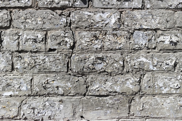 Old brick wall with shreds of paper ads