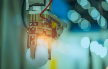 Closeup robot hand machine picking up white ball on bokeh blurred background . Use smart robot in...